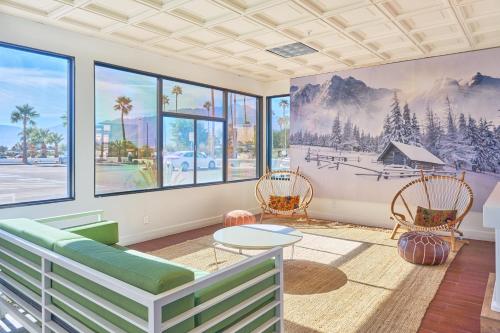 ein Wohnzimmer mit einem Sofa, Stühlen und Fenstern in der Unterkunft Aqua Soleil Hotel and Mineral Water Spa in Desert Hot Springs