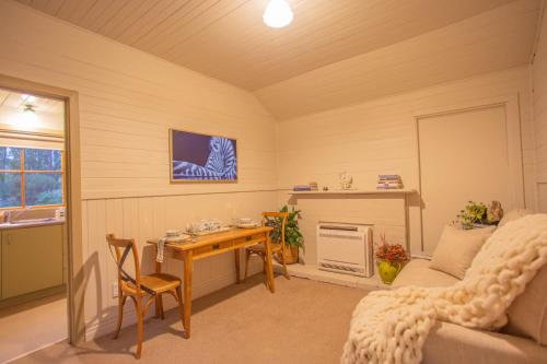 a living room with a table and a couch at Villa City Break for couples 27 mins CHC Airport in Christchurch