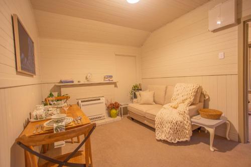a living room with a couch and a table at Villa City Break for couples 27 mins CHC Airport in Christchurch