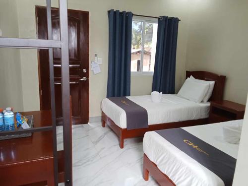 a hotel room with two beds and a window at Coastal Haven Resort in Siquijor