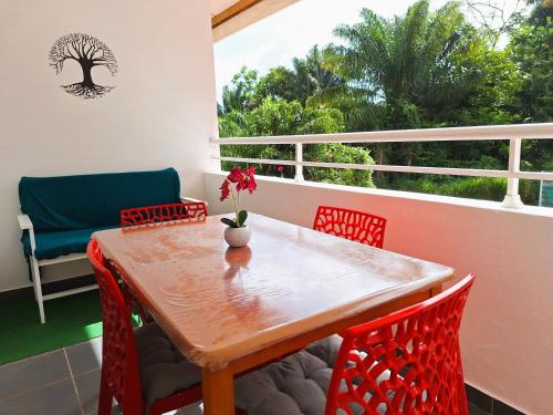 a table and chairs on a balcony with a window at Hello Appart sur Rémire-Montjoly in Bourda