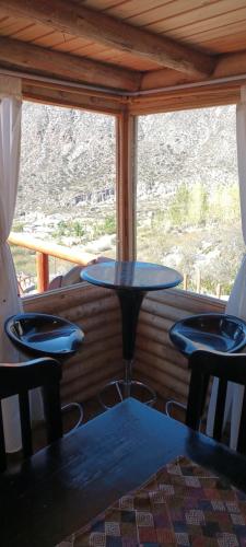 a table and chairs in a room with a window at Cabaña Rincón del Sol in Potrerillos