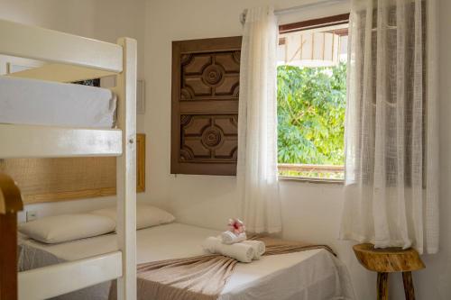 a bedroom with two bunk beds and a window at Pousada Chez Ellery Jeri in Jericoacoara