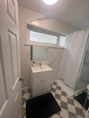 a white bathroom with a sink and a shower at Elegant House in Barnstaple