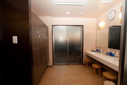 a bathroom with a shower and a sink at Omura Station Hotel in Omura