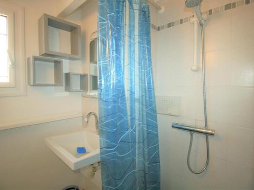 une salle de bain avec une douche avec un rideau de douche bleu dans l'établissement Maison avec Jardin à 150m de la Plage, 2 Chambres, Wi-Fi, Parking, Animaux Acceptés - FR-1-22-351, à La Tranche-sur-Mer