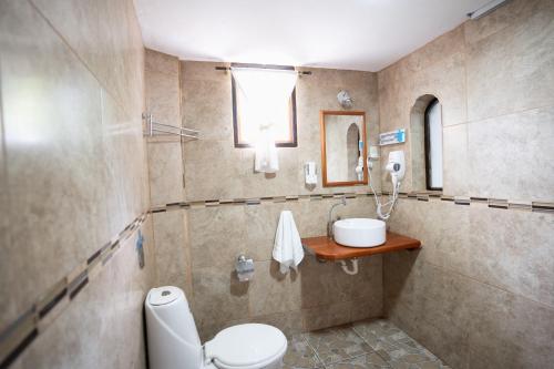 a bathroom with a toilet and a sink at Maidith Galapagos Inn in Puerto Ayora
