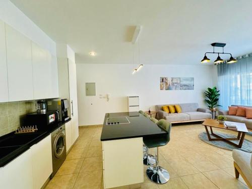 a kitchen and a living room with a couch at Abdoun Place in Amman