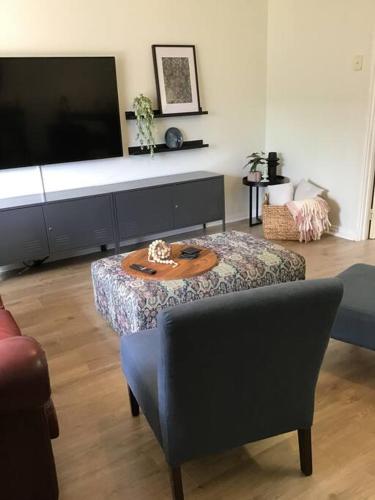 a living room with a table and a tv at Hyacinth Egan in Kalgoorlie