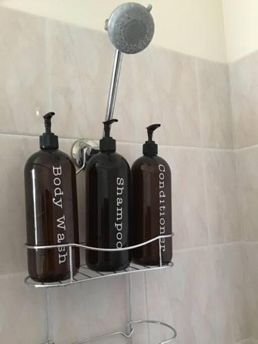 Hyacinth Egan في كالغورلي: زجاجتان سوداوين على رف في الحمام