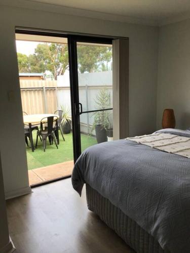 a bedroom with a bed and a patio with a table at Hyacinth Egan in Kalgoorlie