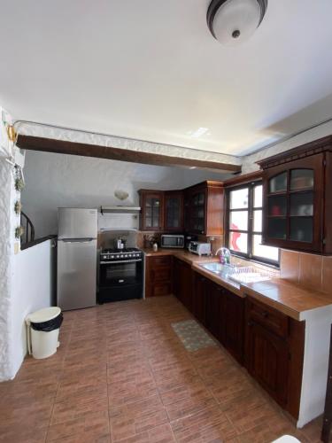 uma cozinha com armários de madeira e um frigorífico branco em Linda Casa en Antigua Guatemala em Guatemala
