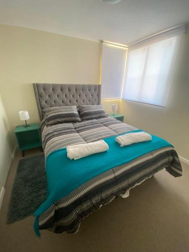 a large bed with two pillows on it in a bedroom at Departamento Full nuevo Curico in Curicó