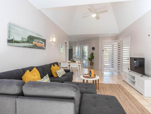 a living room with a couch and a tv at Hastings Cove Holiday Apartments in Hastings Point