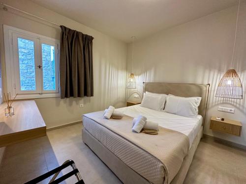 a bedroom with a large bed with two pillows on it at Amorgos Delight in Aegiali