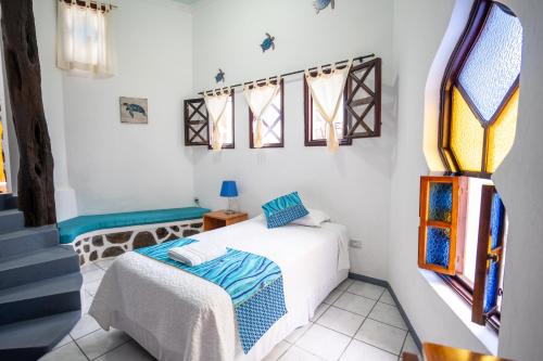a bedroom with a bed and stained glass windows at Maidith Galapagos Inn in Puerto Ayora