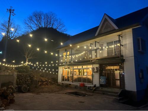 a house with christmas lights on it at night at ゲストハウスみどり in Iiyama