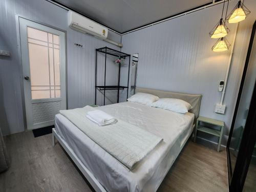 ein Schlafzimmer mit einem großen Bett mit weißer Bettwäsche in der Unterkunft Srithanu Haus in Haad Chao Phao