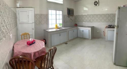 a kitchen with a table with a red box on it at بيت الضيافه98423336 in Ibrā