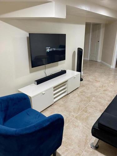 a living room with a flat screen tv and two chairs at Z & Z Apartment 2 in Newark