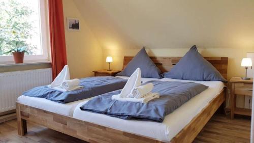 a bedroom with two beds with blue sheets and white towels at Ferienwohnung-Min-Droom in Sankt Peter-Ording