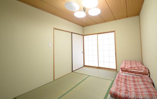 ein Zimmer mit einem Bett in der Ecke eines Zimmers in der Unterkunft のんびれっじ　ハイランド館 in Nasu