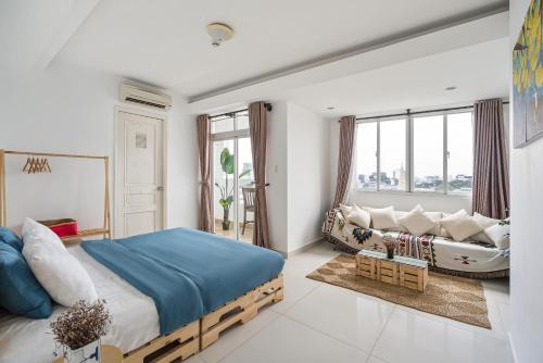 - une chambre avec un lit et un canapé dans l'établissement Alex House Saigon - Serviced Apartment, à Hô-Chi-Minh-Ville