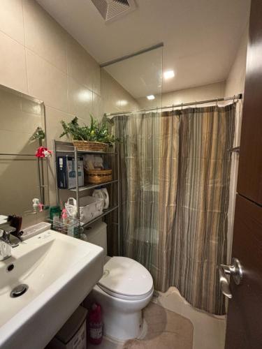 uma casa de banho com um WC, um lavatório e um chuveiro em Saint Honore Condominium em Iloilo