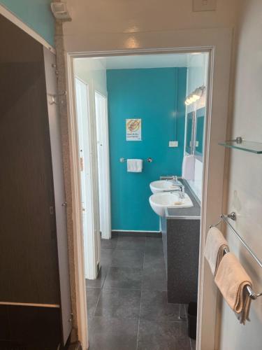 baño con pared azul y lavamanos en UpTown Backpackers en Dunedin