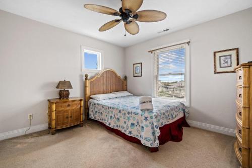 1 dormitorio con 1 cama y ventilador de techo en Anthem of the Sun en Virginia Beach