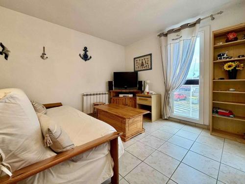 une chambre avec un lit, une télévision et une fenêtre dans l'établissement Appartement cosy à Saint-Georges-d'Oléron, 4 couchages, proche mer et commerces, avec balcon et parking - FR-1-246A-295, à Saint-Georges-dʼOléron
