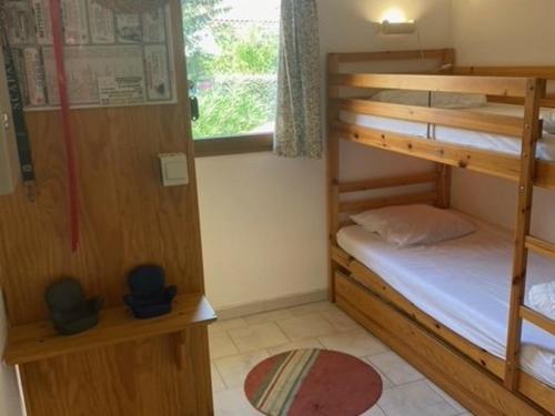 une chambre avec deux lits superposés et une fenêtre dans l'établissement Maison Climatisée avec Piscine/Tennis, Terrasse Orientée Sud-Ouest, Proche Plage - Bormes-les-Mimosas - FR-1-251-821, à Bormes-les-Mimosas