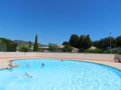 un groupe de personnes nageant dans une piscine dans l'établissement Maison Climatisée avec Piscine/Tennis, Terrasse Orientée Sud-Ouest, Proche Plage - Bormes-les-Mimosas - FR-1-251-821, à Bormes-les-Mimosas