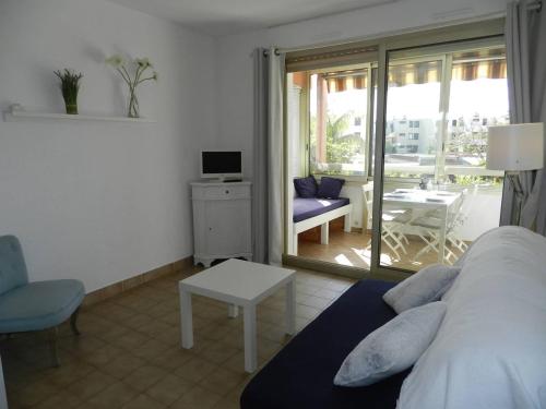 1 dormitorio con 1 cama y sala de estar con balcón. en Appartement Bormes-les-Mimosas, 2 pièces, 4 personnes - FR-1-251-822, en Bormes-les-Mimosas