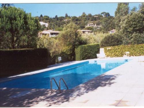 - une piscine bleue avec vue sur une maison dans l'établissement Mazet Duplex 3/4 Pièces Climatisé, Piscine, Proche Plage Croisette - Sainte-Maxime - FR-1-780-77, à Sainte-Maxime
