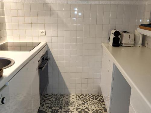 - une cuisine carrelée de blanc avec un comptoir et un évier dans l'établissement Mazet Duplex 3/4 Pièces Climatisé, Piscine, Proche Plage Croisette - Sainte-Maxime - FR-1-780-77, à Sainte-Maxime