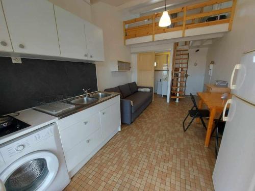 une cuisine avec lave-linge et un salon dans l'établissement Studio mezzanine à 250m de la plage pour 4 personnes - Terrasse, animaux acceptés - FR-1-423-300, au Grau-dʼAgde