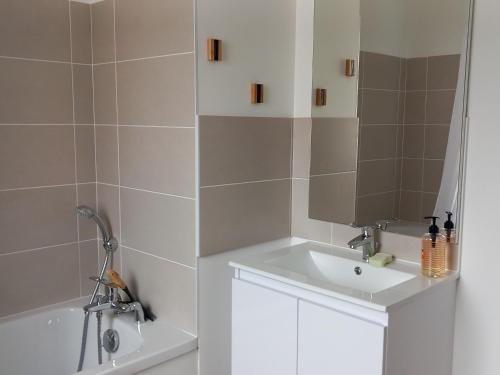une salle de bain avec un lavabo et une baignoire dans l'établissement Maison neuve 2024, confortable et décorée avec goût, proche plage et forêt, wifi gratuit - FR-1-323-531, à Saint-Jean-de-Monts