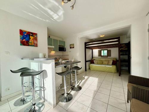 une cuisine avec tabourets de bar et un salon dans l'établissement Appartement 2 pièces, 4 pers, 500m de la plage, véranda, parking privé - FR-1-377-90, à Carnac