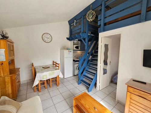 un salon avec un escalier bleu et une table dans l'établissement Maison avec Piscine, Tennis et Lac - Proche Forêt et Plages - Les Mathes - FR-1-550-72, aux Mathes