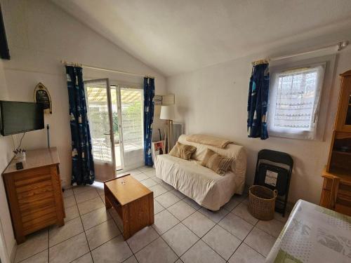 un salon avec un canapé et une télévision dans l'établissement Maison avec Piscine, Tennis et Lac - Proche Forêt et Plages - Les Mathes - FR-1-550-72, aux Mathes