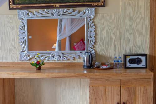 a mirror on top of a dresser in a room at Pondok Kutuh Guest House in Ubud