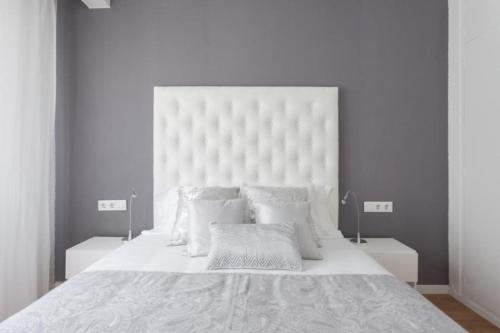 ein weißes Schlafzimmer mit einem großen weißen Bett mit weißen Kissen in der Unterkunft Sunset Boutique Castelldefels by MyRentalHost in Castelldefels