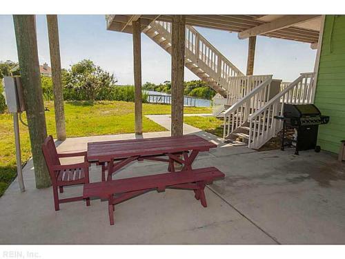 una mesa de picnic y una parrilla junto a una casa en A Free Spirit en Virginia Beach