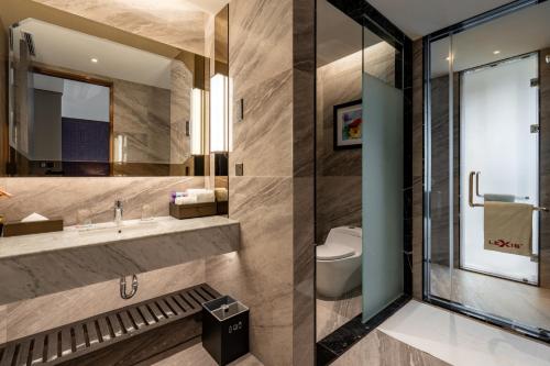 a bathroom with a sink and a toilet at Imperial Lexis Kuala Lumpur in Kuala Lumpur