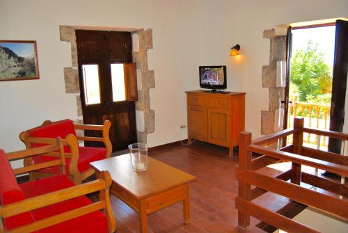 アグイメスにあるCasa Rural El Graneroのリビングルーム(テーブル、椅子、テレビ付)