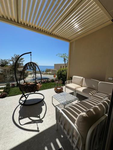 a patio with a couch and a swing at Villa Splendid Palase in Himare