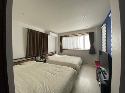 a hotel room with two beds and a television at Wonderful stay TOKYO nakanoshinbashi in Tokyo