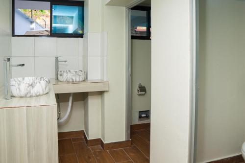 a bathroom with a sink and a mirror at ENJLU INN Selva Central in San Ramón