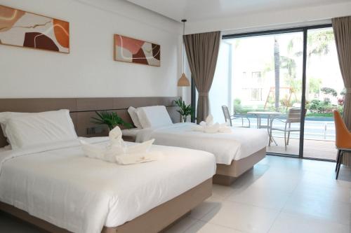 ein Hotelzimmer mit 2 Betten und einem Balkon in der Unterkunft Willander Resort in Panglao